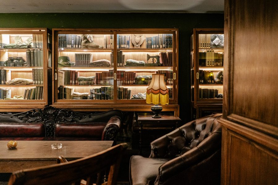 Antique library wall and leather sofas at The Gunslinger's Hop colonial bar Jakarta